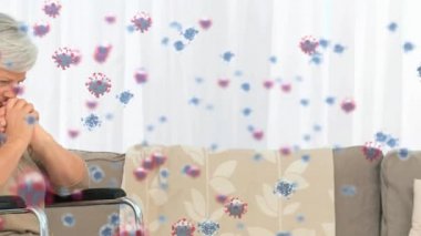 Tekerlekli sandalyede oturan yaşlı beyaz kadının üzerinde süzülen makro Covid-19 hücrelerinin animasyonu. Coronavirus Covid-19 pandemik konsept dijital bileşik
