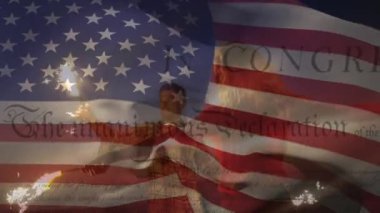 Amerikan bayrağının ABD Anayasası metniyle dalgalanması beyaz bir çiftin maytaplarla oynaması. Amerika Birleşik Devletleri bayrağı ve tatil konsepti dijital kompozisyon