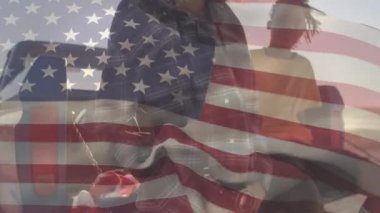 Bir arabanın yanında duran iki melez kadının üzerinde bayrak sallayan Amerikan bayrağının canlandırması. Amerika Birleşik Devletleri bayrağı ve tatil konsepti dijital kompozisyon