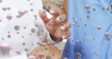 Kafkasyalı yaşlı bir kadının ellerinde süzülen, bir doktorla konuşan makro Covid-19 hücrelerinin animasyonu. Coronavirus Covid-19 pandemik konsept dijital bileşik