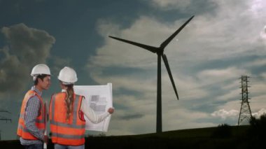 Rüzgar türbininin dönüşünün animasyonu, erkek ve kadın mühendisler arka planda kırsal alan planları okuyor. Küresel çevre sorunları ve dijital olarak üretilen imaj geliştirme kavramı.