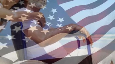 Beyaz bir çiftin kucaklaşması üzerine bayrak sallayan Amerikan bayrağı. Tekerlekli sandalyede oturan bir adam.. 