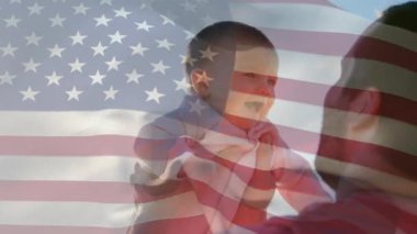 Amerikan bayrağının beyaz bir adamın bebeğini havada tutarken sallanması. Amerika Birleşik Devletleri bayrağı ve tatil konsepti dijital kompozisyon