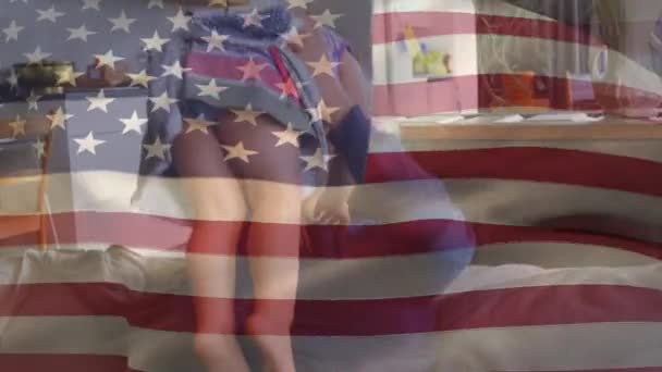 娘と遊ぶ白人男性に手を振って彼女を持ち上げたアメリカの国旗のアニメーション 米国の国旗と休日のコンセプトデジタル組成物 — ストック動画