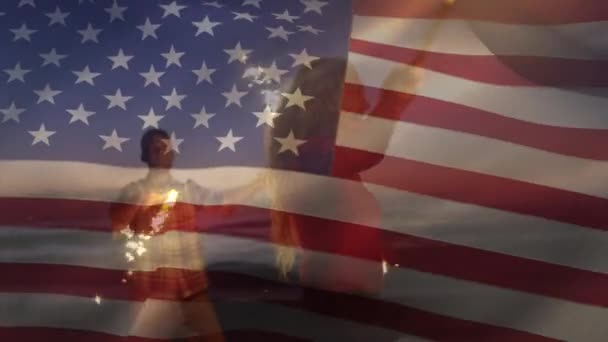 美国国旗飘扬在拿着火花的白种人夫妇身上的动画 美利坚合众国国旗和假日概念数字构图 — 图库视频影像