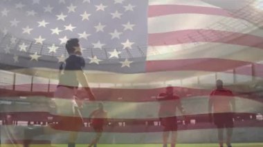 Rugby oynayan, koşan ve iten iki çok ırklı ragbi takımının üzerinde sallanan bir Amerikan bayrağının animasyonu