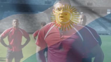 Arjantin bayrağının animasyonu, çok ırklı erkek rugby takımı üzerinde sallanıyor. Saha dijital kompozisyonu üzerinde duruyor.