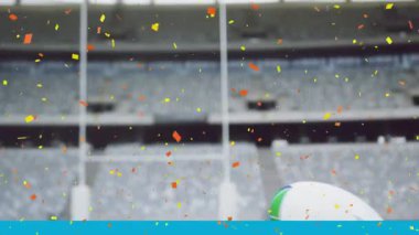 Rugby topunun üzerine düşen turuncu ve sarı konfetilerin animasyonu. Saha dijital kompozisyonu.