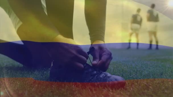靴のデジタル組成物を結ぶ混合レース男性ラグビー選手に手を振ってコロンビアの旗のアニメーション — ストック動画