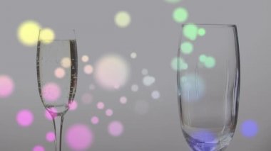 Bir insanın üzerinde yüzen renkli şekillerin animasyonu bir şişeden uzun bir cam dijital kompozisyona şampanya döküyor.