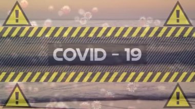 Sarı uyarı işaretleri ve plajda yüzen makro Covid-19 hücreli Covid-19 kelimesinin animasyonu. Coronavirus Covid-19 pandemik konsept dijital bileşik