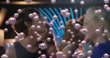 Bir partide dans eden çok ırklı bir grup insanın üzerinde süzülen makro Covid-19 hücrelerinin animasyonu. Coronavirus Covid-19 pandemik konsept dijital bileşik