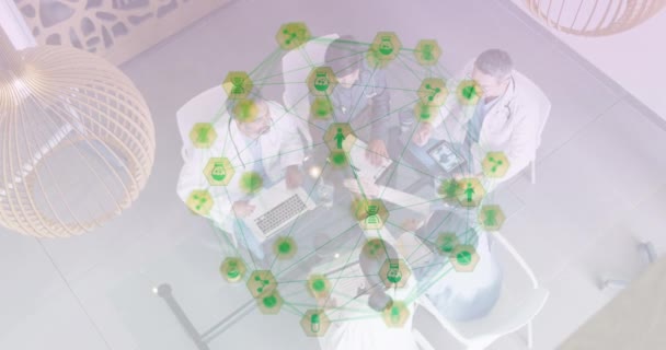 会議中にテーブルに座っている男性と女性の科学者の医師上のインターフェイス医療アイコンとの接続のネットワークのアニメーション グローバルネットワーク科学研究コンセプトデジタル複合体 — ストック動画