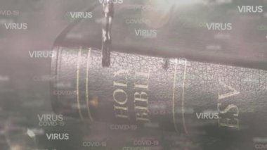 Işık arka planında İncil 'in üzerine düşen Covid-19 kelimelerinin animasyonu. Coronavirus Covid-19 pandemik konsept dijital bileşik