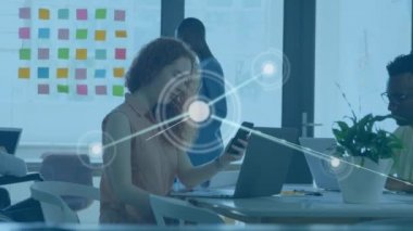 Akıllı telefon ve dizüstü bilgisayar kullanarak bir ofiste çalışan kadın ve erkeğin veri işleme animasyonu. Küresel iş, teknoloji, bağlantı ağı konsepti dijital bileşik.