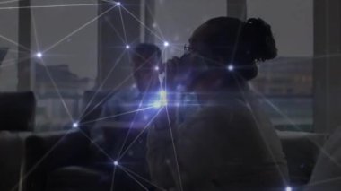 Akıllı telefon ve dizüstü bilgisayar kullanan kadın ve erkeğin üzerindeki bağlantı ve dijital simgelerin animasyonu. Küresel iş ve bağlantı ağı konsepti dijital bileşik.