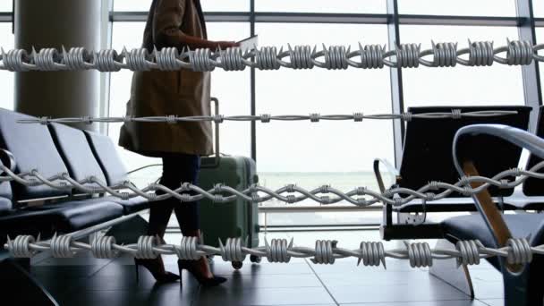 白种人妇女背着行李在机场行走时 铁丝网上的动画 Covid Coronavirus大流行病旅行限制数字复合 — 图库视频影像