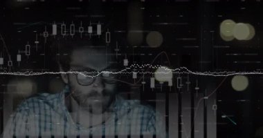 Siyah arka planda bilgisayarıyla çalışan beyaz bir adamın görüşü üzerinde yüzen finansal veri işleme ve çizelgelerinin animasyonu.