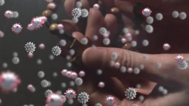 Ellerin üzerinde yüzen, dua eden ve karanlık arka planda tespih tutan makro Covid-19 hücrelerinin animasyonu. Coronavirus Covid-19 pandemik konsept dijital bileşik