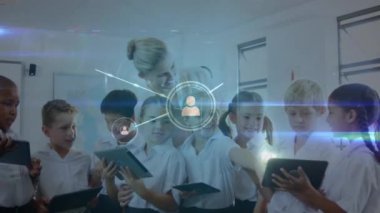 Arka planda dijital tabletler kullanılarak sınıftaki ikonlar, kadın öğretmenler ve okul çocuklarıyla bağlantı ağının animasyonu. Eğitim ve öğretim kavramı dijital kompozit.