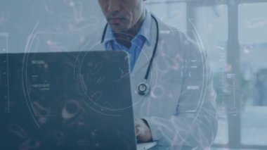 Hastanede dizüstü bilgisayarıyla çalışan melez erkek sağlık çalışanı görüntüsü üzerinde yüzen makro Covid-19 hücresinin animasyonu. Coronavirus Covid-19 pandemik konsept dijital bileşik