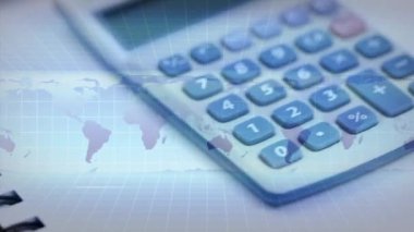 Arkaplanda dönen hesap makinesi, defter ve kalem üzerindeki dünya haritasının animasyonu. Küresel finans ve iş konsepti dijital bileşimi.
