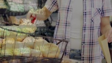 Beyaz bir kadının taze ekmek toplarken, market alışverişinde alışveriş arabasında ve finansal veri işlemede canlandırması. Küresel finans ve alışveriş kavramı dijital bileşik.