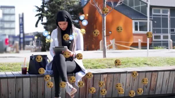 Türbanlı Tablet Kullanan Melez Bir Kadının Üzerinde Yüzen Dijital Emoji — Stok video