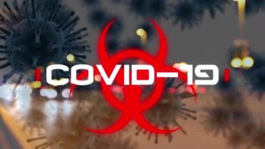 Beyaz kelime COVID-19 ve makro Covid-19 hücreli kırmızı biyolojik tehlike ikonunun animasyonu arka planda gece sokak manzarasında yüzüyor. Coronavirus Covid-19 pandemik konsept dijital bileşik.