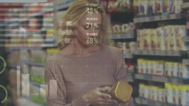 Beyaz bir kadının marketten alışveriş yapıp fiyatları ve finansal veri istatistiklerini kontrol etmesi. Küresel finans ve alışveriş kavramı dijital bileşik.