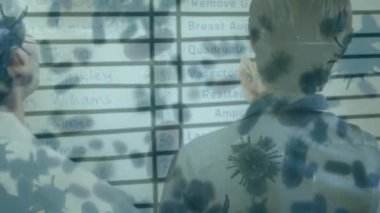 Hastanede tartışan çok ırklı erkek ve kadın sağlık çalışanlarının görüşü üzerinde yüzen makro Covid-19 hücrelerinin animasyonu. Coronavirus Covid-19 pandemik konsept dijital bileşik