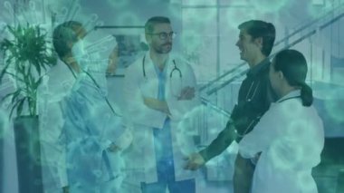 Bir grup erkek ve kadın sağlık çalışanının hastanede tartıştıkları bir görüntü üzerinden yüzen ve veri işleyen Coperid 19 hücrelerinin animasyonu. Coronavirus Covid-19 pandemik konsept dijital bileşik.