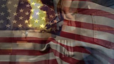Arka planda maşayla sıcak metal tutan fabrikada çalışan adamın üzerinde Amerikan bayrağının dalgalanması. Amerikan toplumu kalkınma vatanseverlik kavramı dijital kompozisyon.