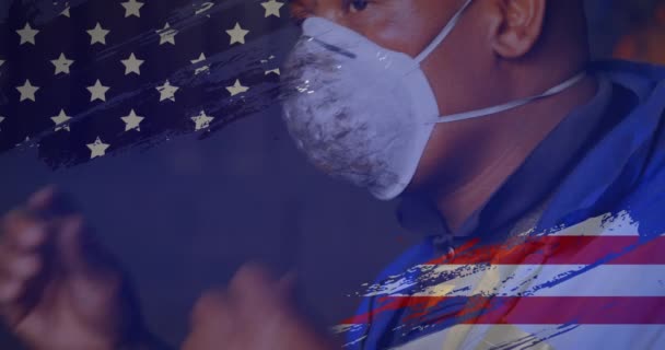 在工厂工作的混血儿上 美国国旗的动画在幕后摘下了面具 美国社会多样性爱国主义概念数字构成 — 图库视频影像