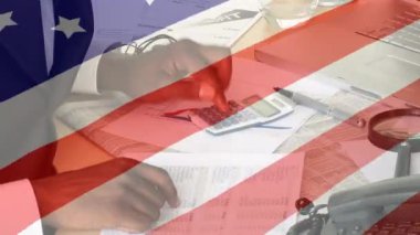 Arka planda hesap makinesi kullanarak iş adamının üzerinde dalgalanan Amerikan bayrağının animasyonu. Amerikan toplumu çeşitlilik kavramı dijital kompozisyon.