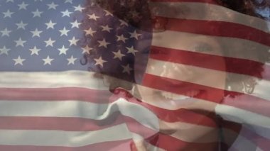 Arka planda, yaz tatilinde sahilde mutlu melez kadın bayrağını dalgalandıran animasyon. Amerikan toplumu çeşitlilik kavramı dijital kompozisyon.