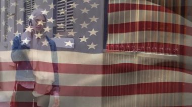 Arka planda Amerikan bayrağının tesettürlü kadın üzerinde yürüdüğü ve akıllı telefonuyla konuştuğu animasyon. Amerikan toplumu çeşitlilik kavramı dijital kompozisyon.