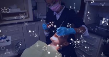 Dişçi koltuğundaki kadın hastayı tedavi eden yüz maskeli kadın dişçinin üzerinden akan moleküllerin animasyonu. Tıbbi diş tedavisi Covid 19 koronavirüs koruma konsepti dijital bileşik.