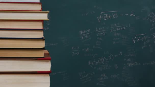 背景に緑の黒板を持つ本のスタック上の数学式のアニメーション 科学問題解決教育概念デジタル生成画像 — ストック動画