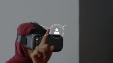 Dijital simgelerin ve istatistiklerin canlandırılması ve VR kulaklık takan ve parmaklarıyla dokunan karışık ırktan bir kadınla dijital ağ arayüzü konsepti dijital bileşimi.