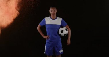 Arka planda duman patlamasına karşı elinde top tutan kadın futbolcunun dijital kompozit videosu