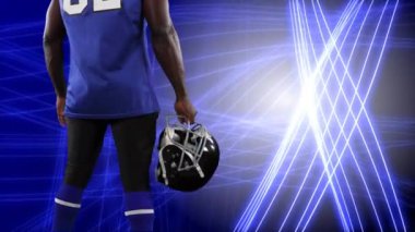 Mavi zemin üzerinde parlayan çizgilere karşı elinde kask tutan erkek rugby oyuncusunun arka planının dijital kompozit videosu.