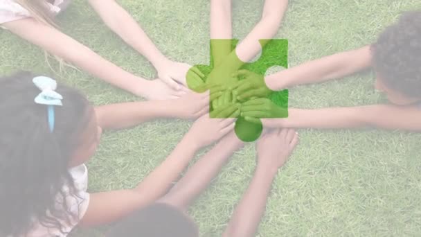 ジグソーパズルのデジタル複合ビデオは 庭に手を合わせて子供たちに対して正方形を形成します 自閉症意識の概念 — ストック動画