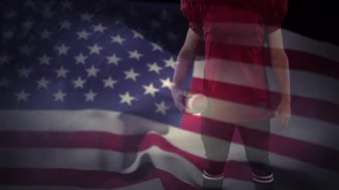 Amerikan bayrağını sallayan rugby topu tutan erkek ragbi oyuncusunun orta bölümünün dijital kompozit videosu. Spor fitness konsepti dijital kompozit