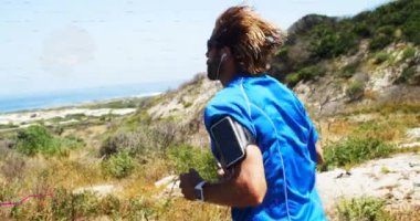 Dağlarda akıllı telefonla koşan bir adamın veri kaydıyla dijital arayüzün animasyonu. Dijital olarak oluşturulan küresel dijital konsept.