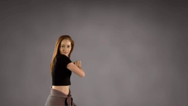 灰色の背景を背景に踊る若い女性のデジタル複合ビデオ 創造的な表現 若さのエネルギー ファッション ダンスの概念 — ストック動画
