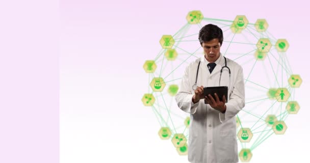 在医生佩戴听诊器的上方旋转的绿色数字图标的球面的数字合成视频 使用数字平板在粉色背景下 全球联网和医学研究概念 — 图库视频影像