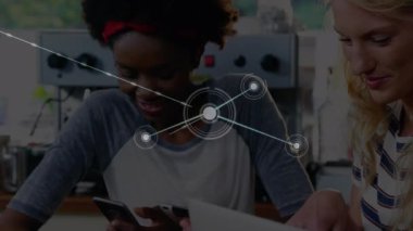 Ofiste dijital tablet ve akıllı telefon kullanan iki kadın ve erkek arasındaki bağlantı ağının animasyonu. Çevrimiçi ağ dijital arayüz teknolojisi konsepti dijital olarak oluşturuldu.