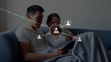 Evde dijital tablet kullanan çiftlere karşı bağlantı simgelerinin canlandırılması. Çevrimiçi ağ dijital arayüz konsepti dijital olarak oluşturuldu.