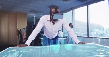 VR kulaklık takan bir iş adamının animasyonu. Masada 3D planı var.